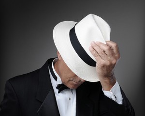 Dapper man in white fedora, face partially obscured.