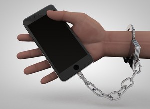 Photo of cell phone chained to a human hand.
