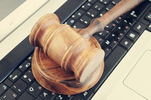 Photo of wooden gavel on a black computer keyboard.